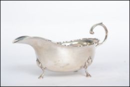 A silver hallmarked sauce boat raised on cabriolet