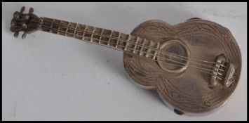 A silver 925 vesta case in the form of a guitar ha