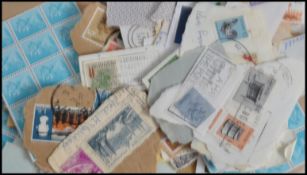 A collection of kiloware loose stamps and stamp al