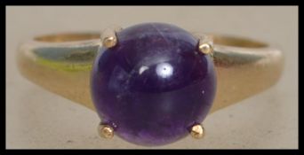 A Hallmarked 9ct gold ring set with a amethyst cab
