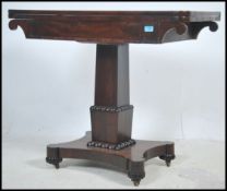A Regency mahogany card table raised on a quadrupe