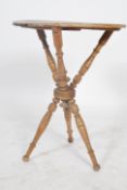 A Victorian country cricket / gypsy fortune tellers table raised on turned cross over legs with