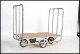 An early 20th century industrial bank trolley of tubular steel construction having a wooden panelled