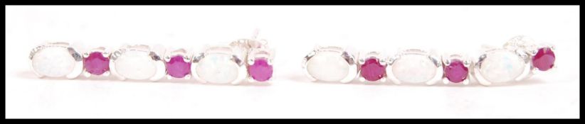 A pair of silver opal and garnet drop earrings, th