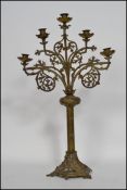 A 19th century French ecclesiastical five arm candelabra raised on a hexagonal pierced base with