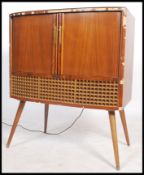 A stunning vintage 20th century Decca valve radiogram, having tambour doors to front opening to