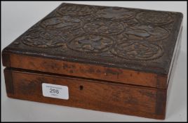 A 19th century mahogany box of square form with dual barrel lock with carved medallions to lid
