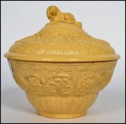 A 19th century Victorian Wedgwood cream basalt cane ware (caneware) lidded pot having a dog finial