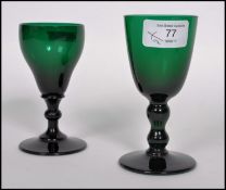 Two 18th century Georgian Bristol green glass wine glasses one raised on a plain foot with knopped