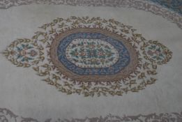 A large Indian Firdosh 20th century floor rug with beige colourway having blue borders with