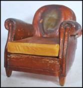 A 1930's French leather club armchair being raised on squared legs with cloud shaped back rest