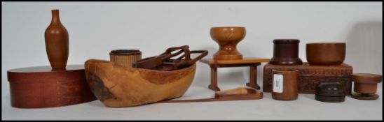 A collection of wooden treenware items to include beakers, pots, lidded pots etc
