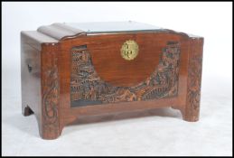 A mid century Chinese - oriental camphor wood blanket box of unusual form, with carved depiction