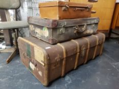 A stack of vintage early 20th century trunks to include a canvas and wooden bound steamer trunk
