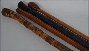 A group of four vintage walking sticks to include a silver hallmarked example, a fruit wood example,