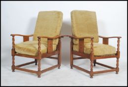 A pair of 1920's oak barleytwist fireside armchairs being raised on barleytwist legs united by