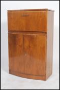 A 1940's art deco walnut veneer drinks cabinet with a metamorphic top opening action to reveal a