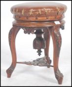 A Victorian tripod piano stool in walnut having lavishly carved cabriole legs and a faux leather
