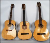 A group of three vintage acoustic guitars one bein