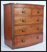 A Victorian mahogany bow front chest of drawers having spiral columns flanking the 2 short over 3