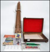 A vintage 20th century metamorphic folding artists easel along with a collection of artist paint and