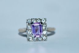 A hallmarked 9ct gold purple sapphire and white stone cluster ring. Hallmarked Birmingham. Size K.