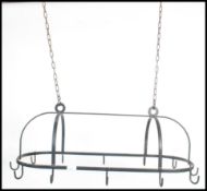 A 20th century cast iron ebonised chain hung pan rack of lozenge shape with hooks to banded sides.