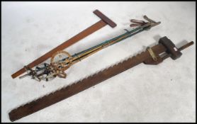 A very large vintage wooden sash clamp along with two sets of vintage ski poles and a mahogany set
