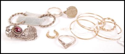 A collection of silver and gold jewellery items to include gold creole earrings, a silver Art