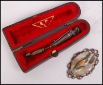 A sterling silver and abalone pendant with ribbon sides together with a Sterling Scottish silver and