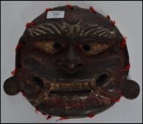 An early 20th century Japanese Kabuki / Noh theatre mask being handpainted in brown and red paints
