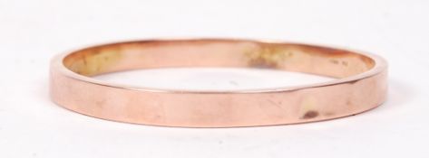 A 9ct rose gold bangle bracelet by Henry Griffith and Sons having a plain design being stamped 9ct