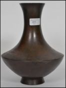 A 19th century Oriental Chinese bronze vase with ovoid base and tapering neck and sprayed rim.