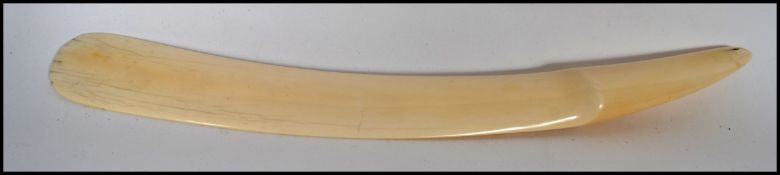 A 19th century Victorian ivory page turner having a shaped rounded end with the handle retaining the