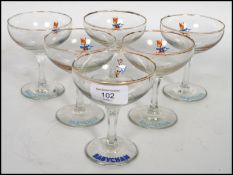 A set of 6 1960s Babycham glasses raised on a plai