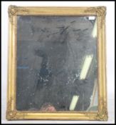 A late 19th Century French gilt wall mirror having a moulded trailing decoration bead trim frame.