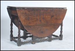 A good 18th / 19th century peg jointed country oak drop leaf dining table raised on block and turned