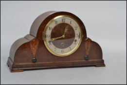 A 1930's Art Deco napoleon hat clock mechanical mantel clock having a numerical face and 3 train