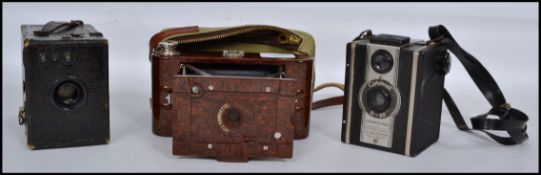 A collection of vintage 20th century cameras to include a Kodak Hawkette No2 folding camera, a box