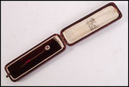 A 9ct gold seed pearl and ruby ladies stick pin / hat pin complete in the original tooled red