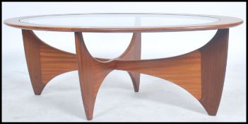 A 1970's retro teak wood atomic oval coffee table by G Plan, having a drop centre glass panel.