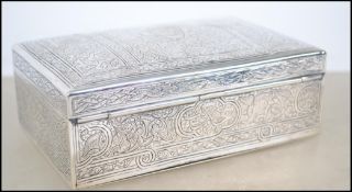 An Egyptian silver table top cigarette box chase decorated with geometric borders and ornate chase