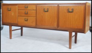 A 1970's Danish influence teak wood sideboard of low and long form raised on tapering legs with a