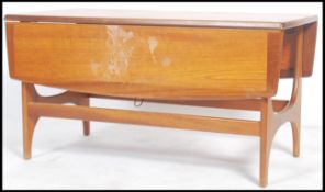 A 1970's retro teak wood drop leaf coffee occasional table. Of rectangular form having magazine rack