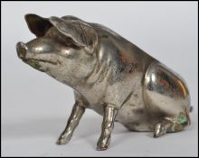 A 20th century novelty silver plated pig pin cushion moulded in a seated position. Lacking cushion