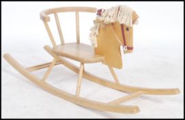 A retro 1960's childs sit on wooden rocking horse having spindle gallery seat with horse head and