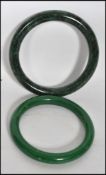 Two 20th century Chinese jade bangles of differing shades of green one being a very deep rich