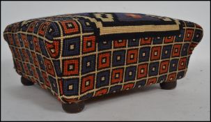 A Victorian /  early 20th century tapestry upholstered footstool in the sarcophagus form being