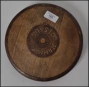 An early 20th century discus of wooden and cast metal banding with notation to centre for '