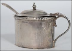 An early 20th century hallmarked silver condiment with blue glass liner finial lid and serpentine